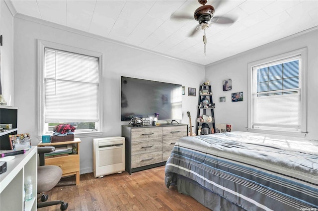 bedroom featuring ceiling fan, crown molding, and dark hardwood / wood-style floors