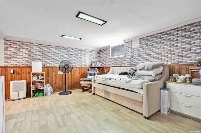 bedroom with brick wall, ornamental molding, wooden walls, and light hardwood / wood-style flooring