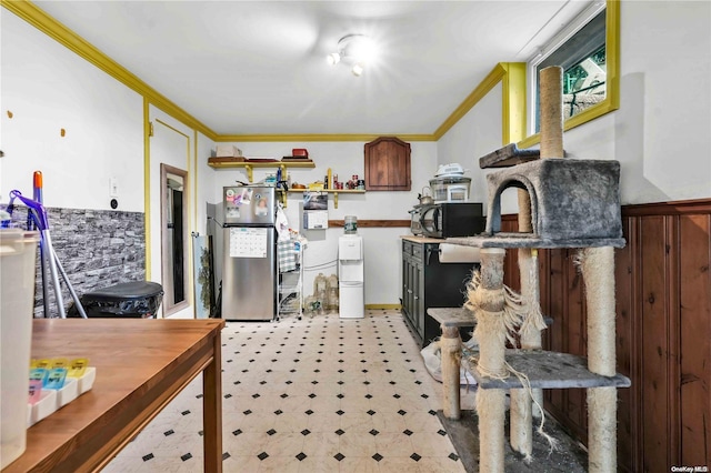 kitchen with stainless steel refrigerator and crown molding