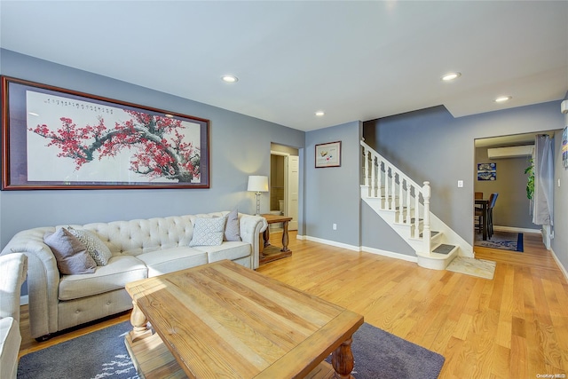 living room with hardwood / wood-style flooring and a wall unit AC