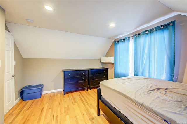 bedroom featuring light hardwood / wood-style floors and lofted ceiling