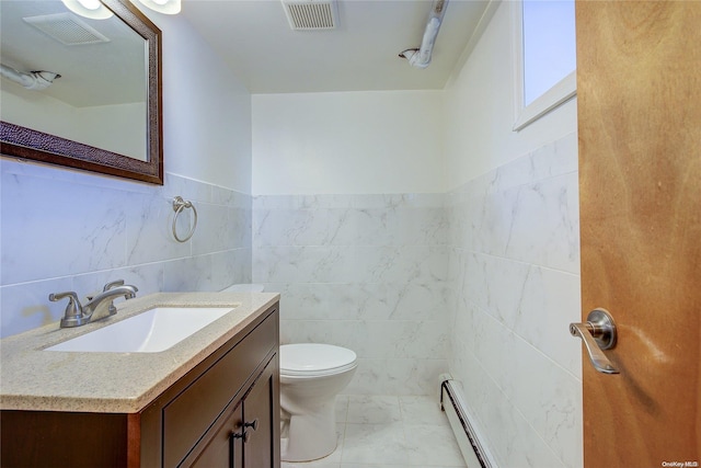 bathroom with vanity, toilet, and tile walls