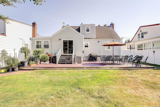 rear view of property featuring a wooden deck and a yard