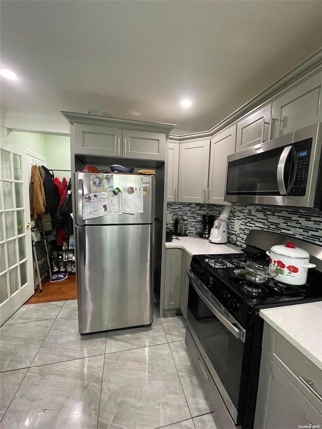 kitchen featuring tasteful backsplash, gray cabinets, and stainless steel appliances