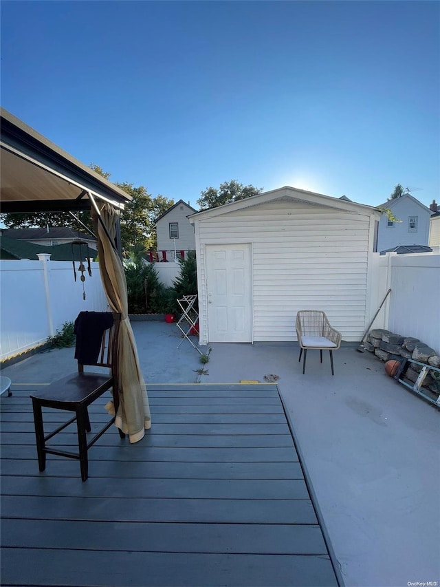 wooden deck featuring a gazebo, a patio, and a storage shed