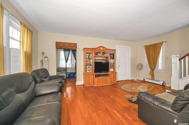 living room with a healthy amount of sunlight, wood-type flooring, and a baseboard radiator