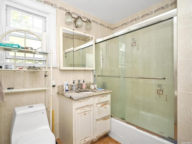 full bathroom featuring combined bath / shower with glass door, vanity, and toilet