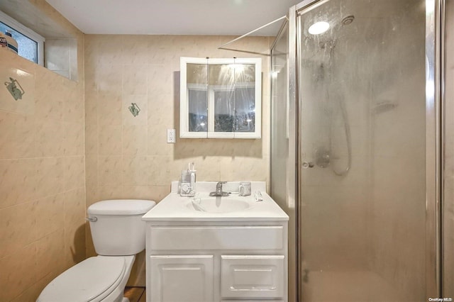 bathroom featuring vanity, toilet, tile walls, and a shower with shower door