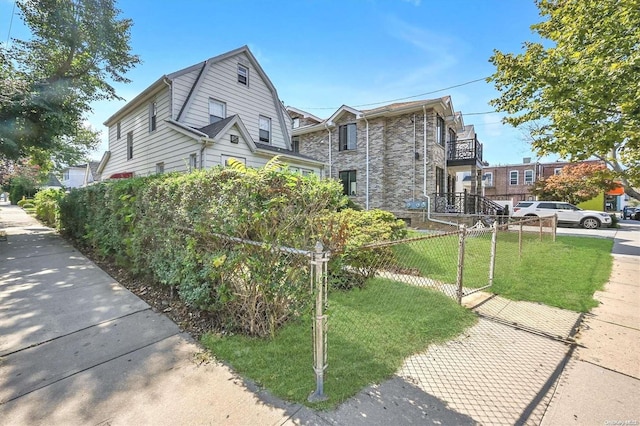 view of front of property featuring a balcony and a front yard