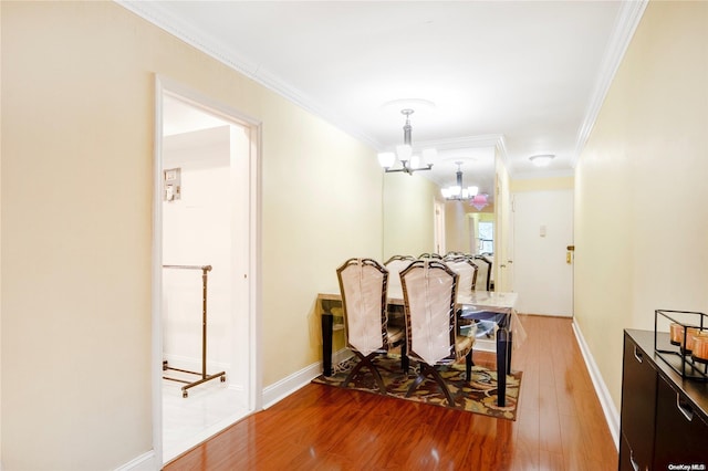 dining area with a chandelier, hardwood / wood-style flooring, and ornamental molding