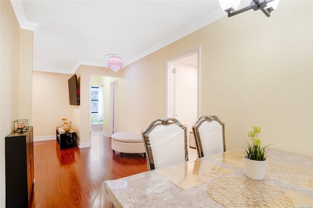 dining room featuring hardwood / wood-style floors, an inviting chandelier, and ornamental molding