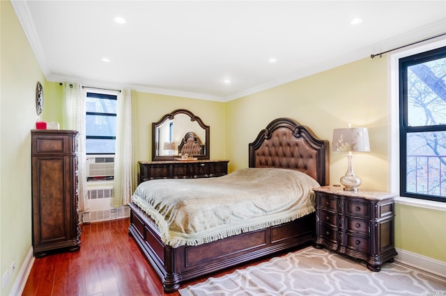 bedroom featuring hardwood / wood-style floors, crown molding, and multiple windows