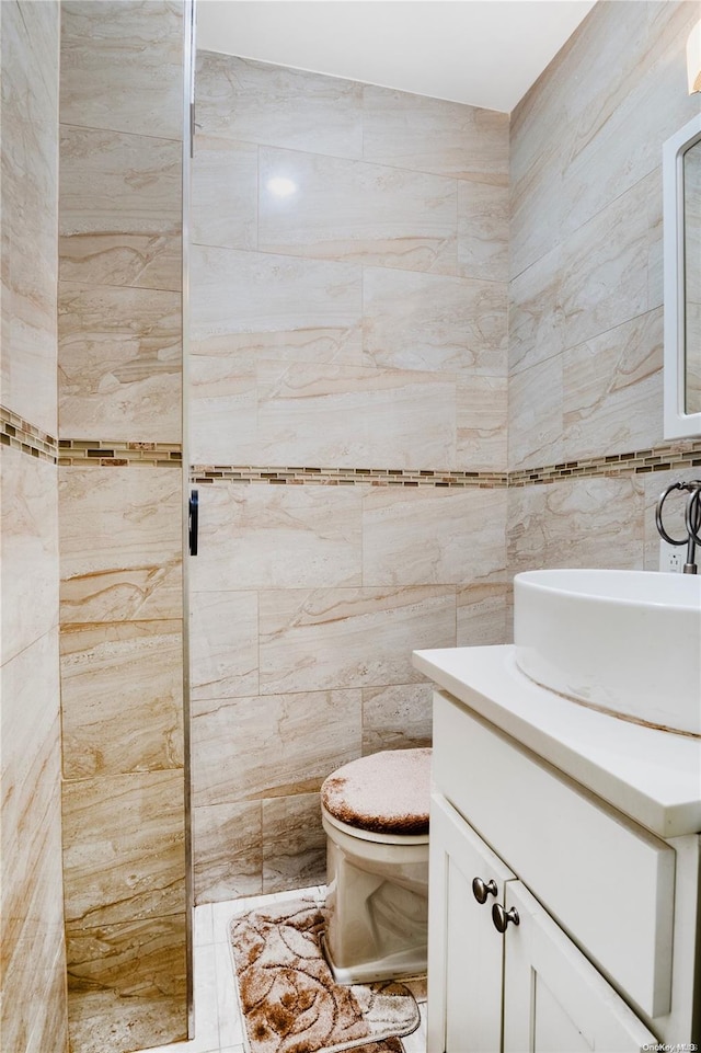 bathroom featuring vanity, toilet, and tile walls