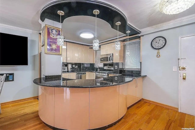 kitchen with hanging light fixtures, kitchen peninsula, crown molding, appliances with stainless steel finishes, and light wood-type flooring