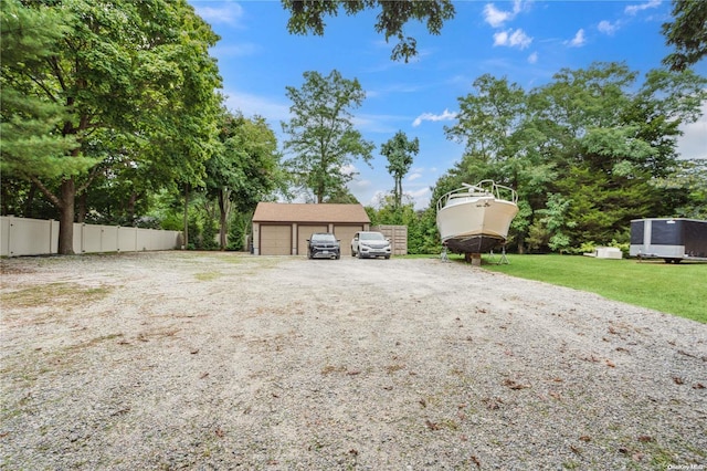 view of yard featuring a garage and an outbuilding