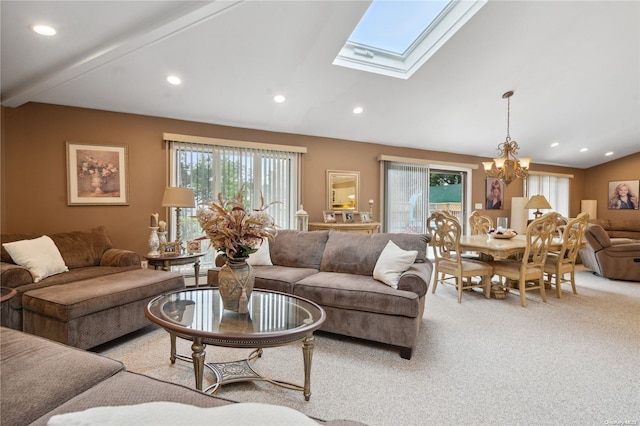 living room featuring a chandelier, light colored carpet, a baseboard radiator, and vaulted ceiling with skylight