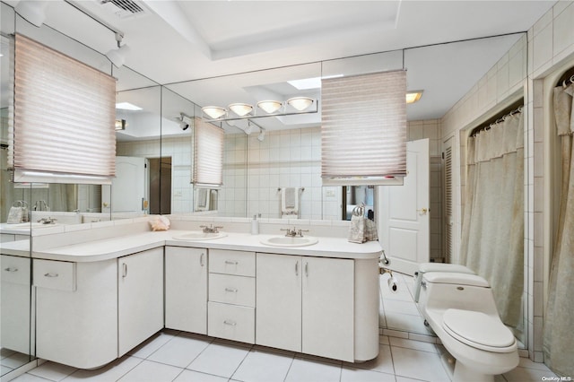 bathroom featuring a shower with shower curtain, tile patterned floors, vanity, tile walls, and toilet