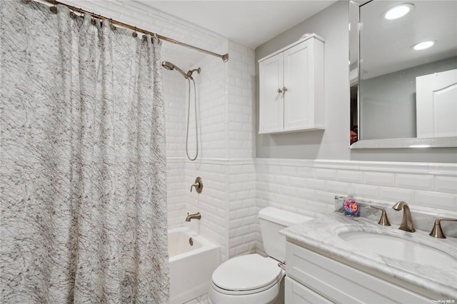 full bathroom with vanity, toilet, tile walls, and shower / tub combo