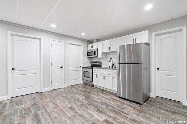 kitchen featuring white cabinets, light wood-type flooring, and appliances with stainless steel finishes