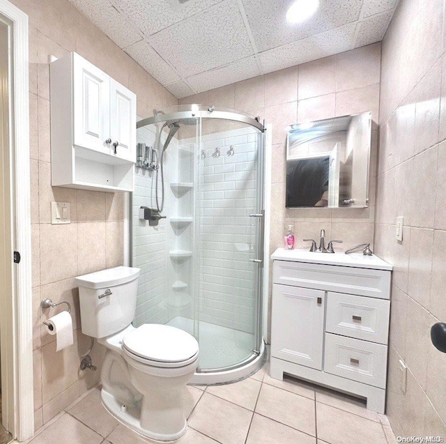 bathroom with tile patterned flooring, toilet, and tile walls