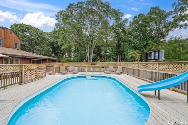 view of pool featuring a deck and a water slide