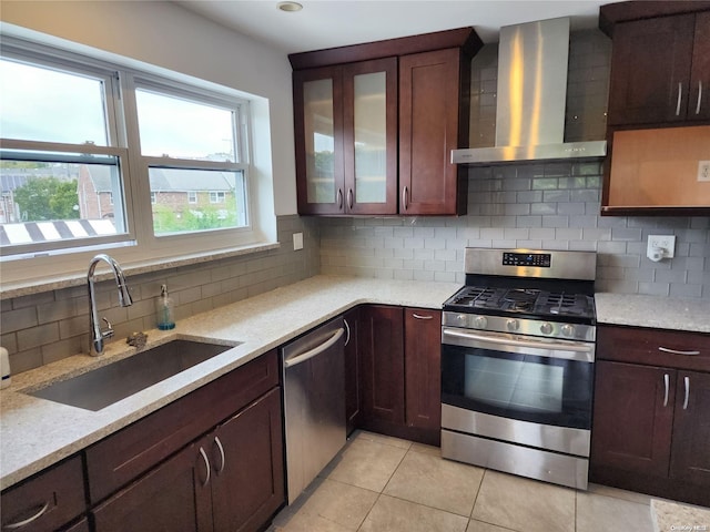 kitchen with light stone countertops, sink, wall chimney exhaust hood, backsplash, and appliances with stainless steel finishes