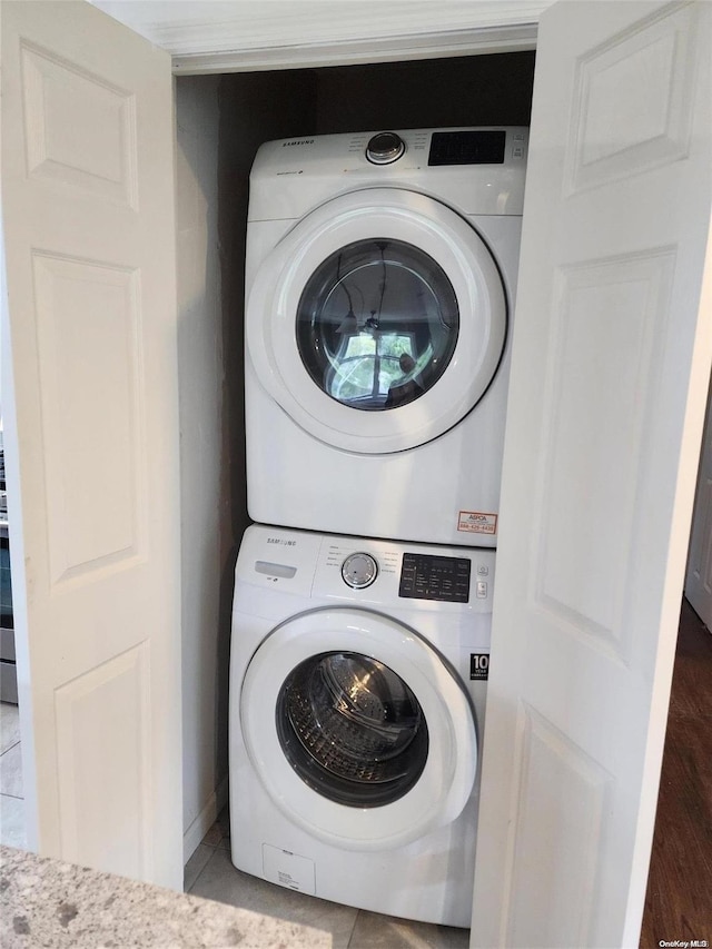 washroom with tile patterned floors and stacked washer / drying machine