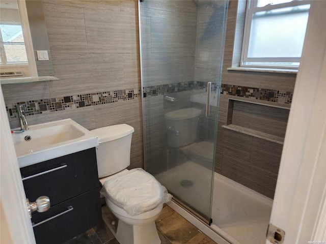 bathroom with a wealth of natural light, an enclosed shower, tile walls, and toilet