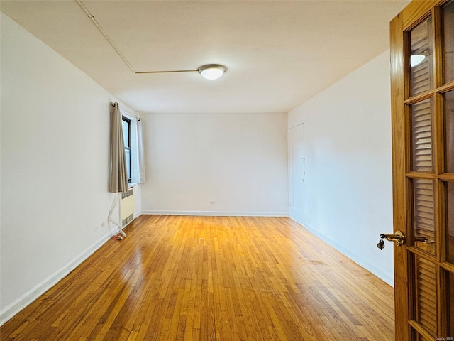empty room featuring light wood-style floors and baseboards
