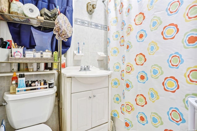 bathroom featuring a shower with curtain, vanity, tile walls, and toilet