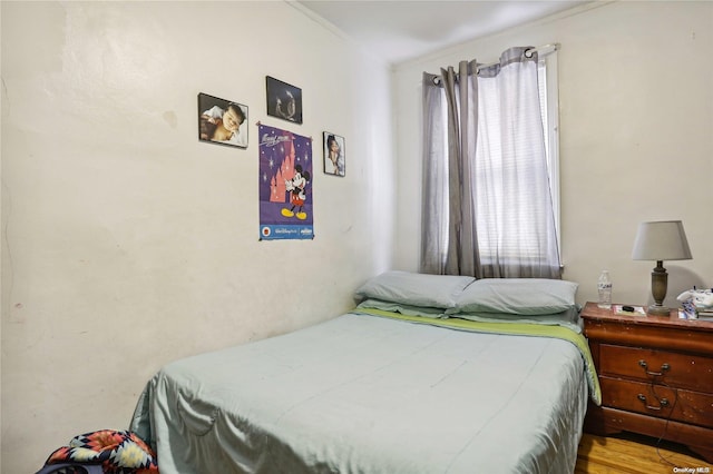 bedroom with crown molding and light hardwood / wood-style floors