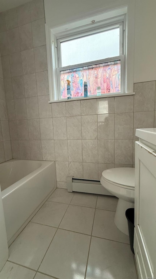 bathroom featuring baseboard heating, tile patterned floors, toilet, vanity, and tile walls