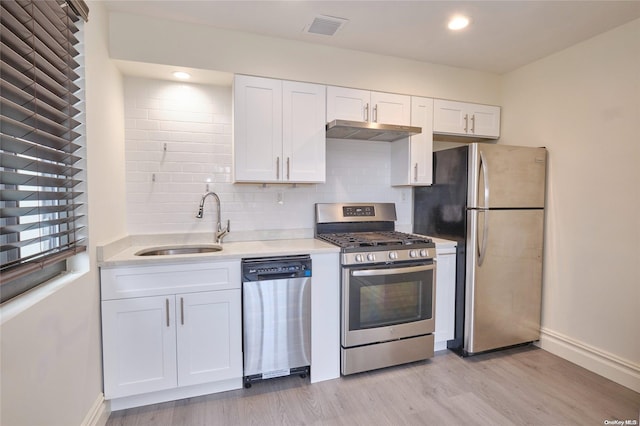 kitchen featuring white cabinetry, sink, light hardwood / wood-style floors, and appliances with stainless steel finishes