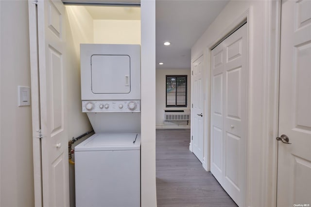 washroom featuring light hardwood / wood-style flooring and stacked washing maching and dryer