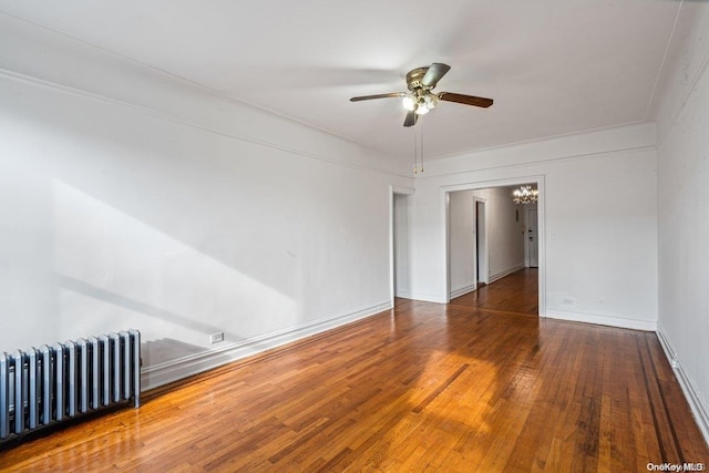 empty room featuring ceiling fan, wood-type flooring, and radiator heating unit