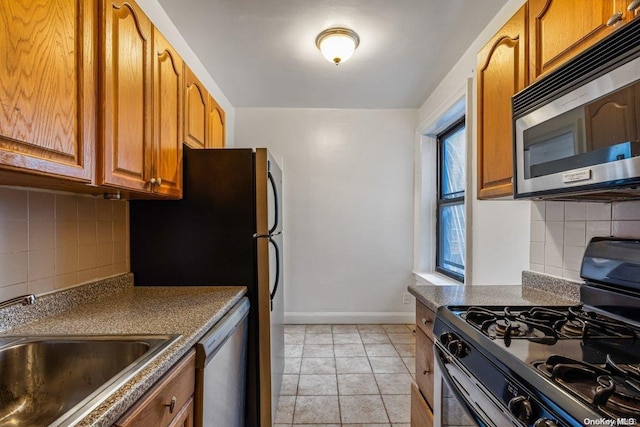 kitchen featuring black appliances, decorative backsplash, sink, and a wealth of natural light