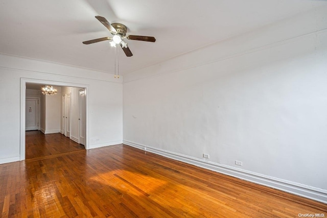 unfurnished room with dark hardwood / wood-style floors and ceiling fan with notable chandelier