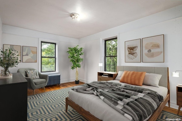 bedroom featuring wood-type flooring and radiator heating unit