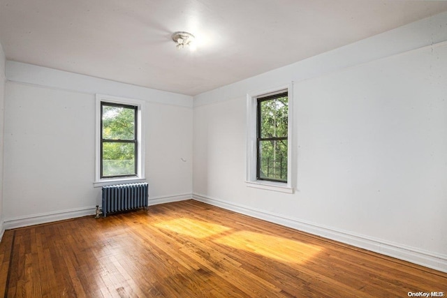 spare room with radiator and hardwood / wood-style flooring