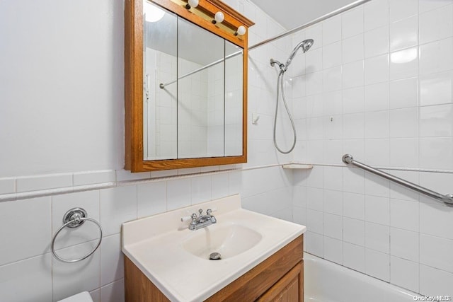 bathroom with vanity, tile walls, and tiled shower / bath combo