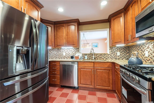 kitchen featuring backsplash, light stone counters, sink, and stainless steel appliances