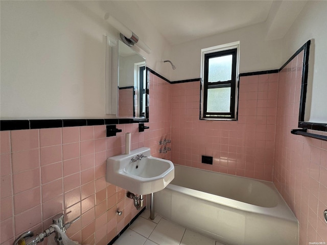 bathroom featuring sink, tile patterned flooring, tile walls, and tiled shower / bath