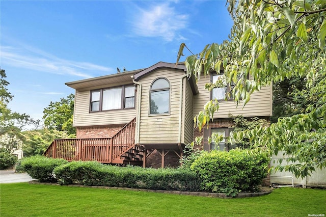 rear view of house featuring a deck and a lawn