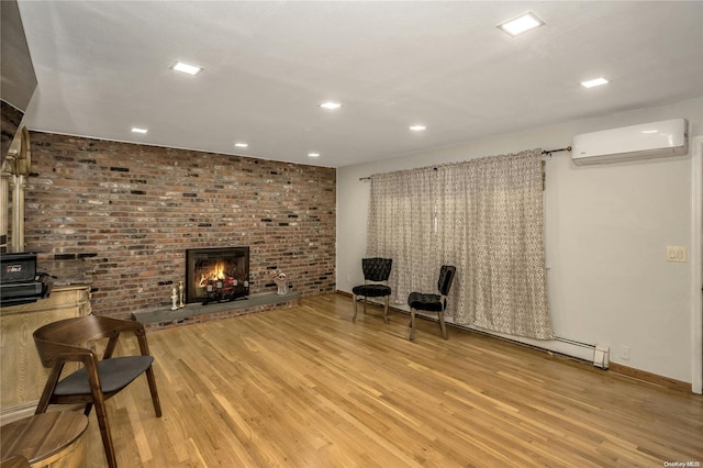 unfurnished room with a brick fireplace, light wood-type flooring, brick wall, and a wall mounted AC