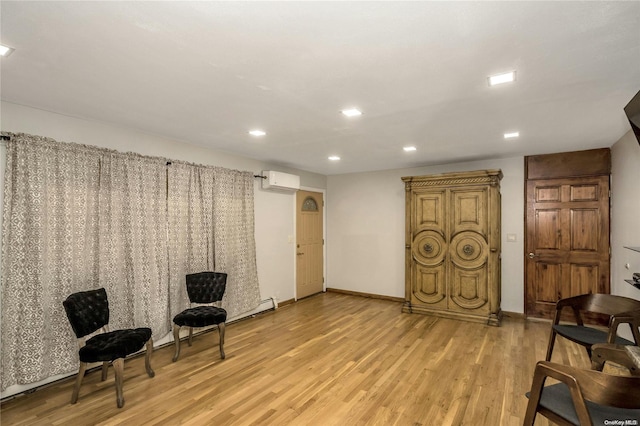 living area featuring light hardwood / wood-style floors and an AC wall unit