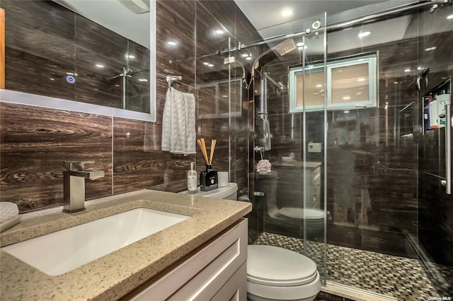 bathroom featuring vanity, an enclosed shower, tile walls, and toilet