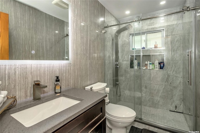 bathroom featuring walk in shower, vanity, tile walls, and toilet