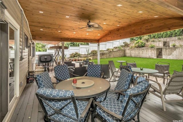 wooden terrace with a lawn and ceiling fan