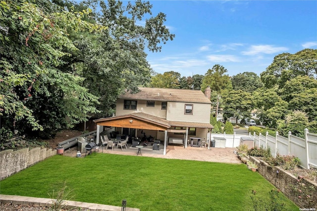 back of property featuring a patio area and a lawn