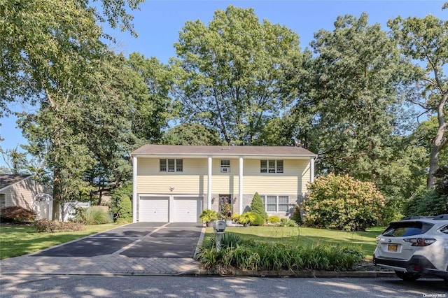 bi-level home with a garage and a front yard